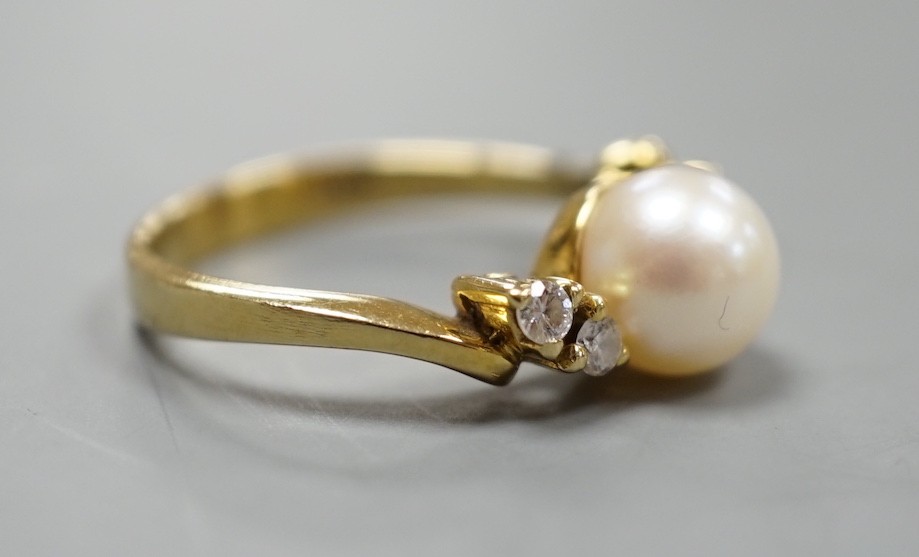 A 14kt yellow metal and single stone cultured pearl ring, with diamond set shoulders, size J, gross weight 3.4 grams.